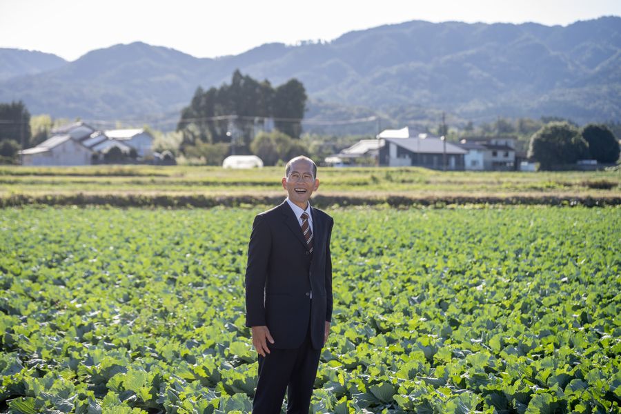 畑に立つ豊田まさお